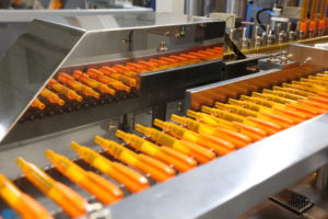 Orange pens lined up in a factory