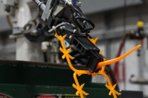 Factory machine with orange wire-like wrapped around it