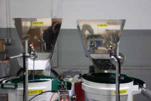 Close of 2 factory machines with white and black tubes in each