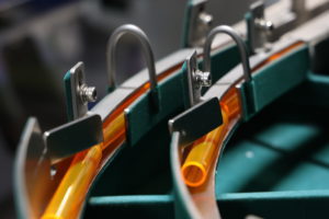 Orange tubes lined up in a factory