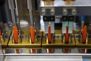 Orange pens lined up in a factory