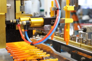 Orange pens lined up in a factory