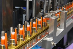 factory machine inserting orange pens