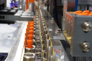 factory machine inserting orange pens